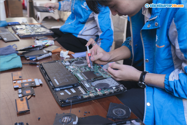 Kỹ thuật viên tra kem tản nhiệt làm mát cho laptop